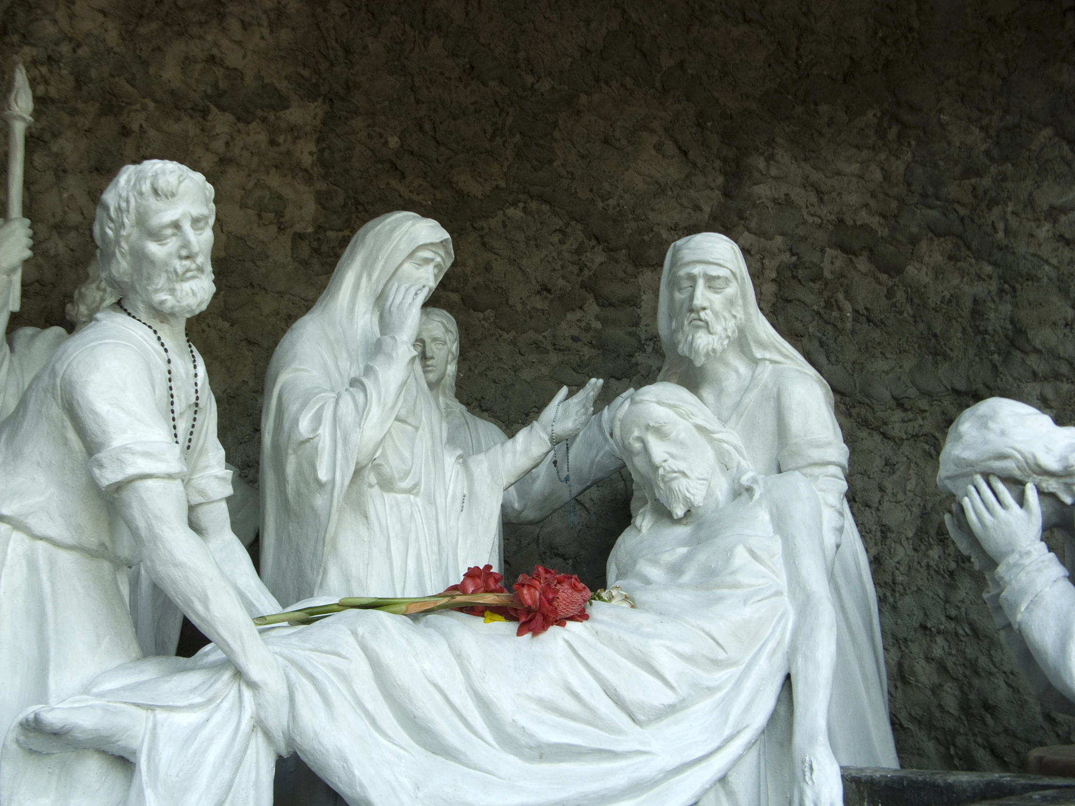 this image shows an outdoor sculpture with a memorial depicting jesus