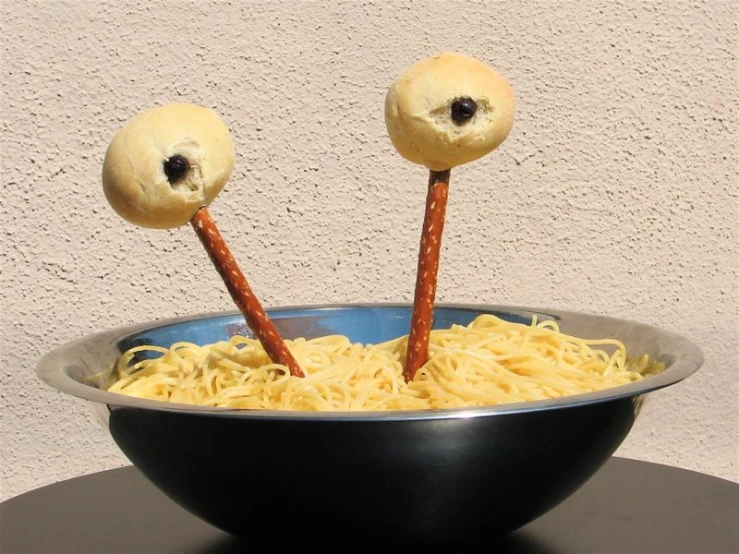a bowl that has spaghetti in it and two googly eyes on top