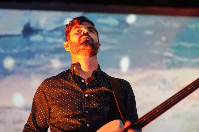 the man is playing a musical instrument and watching television