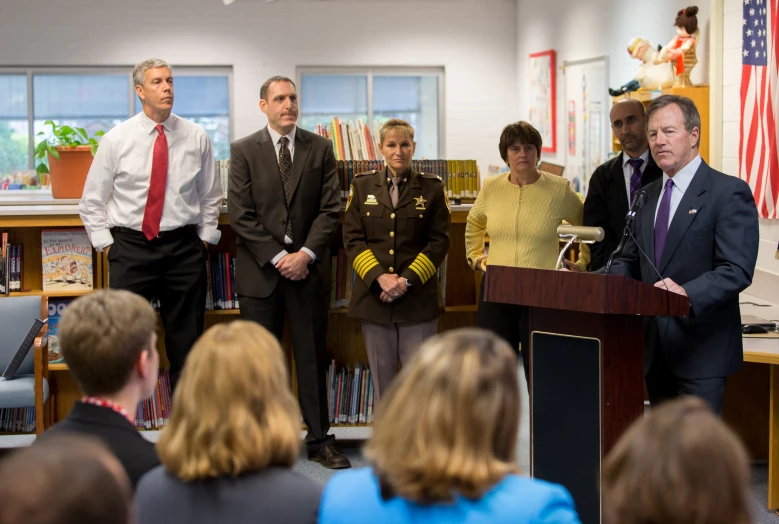 people wearing suits and tie in front of a podium