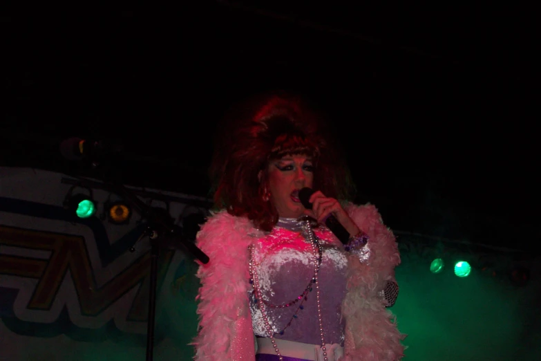 a woman in purple and pink outfit holding a microphone