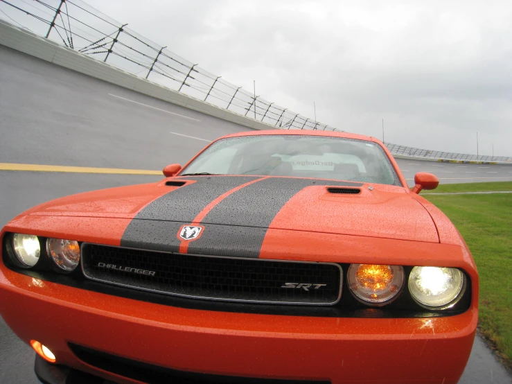 this red and black dodge car is driving on the track