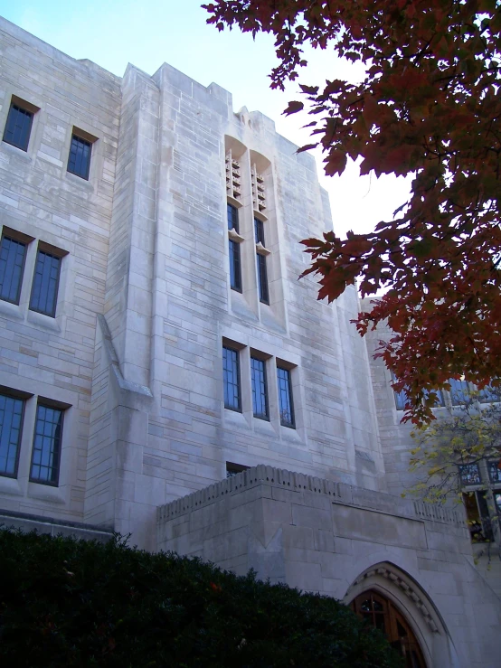 a very tall white building with two stories and a big lawn