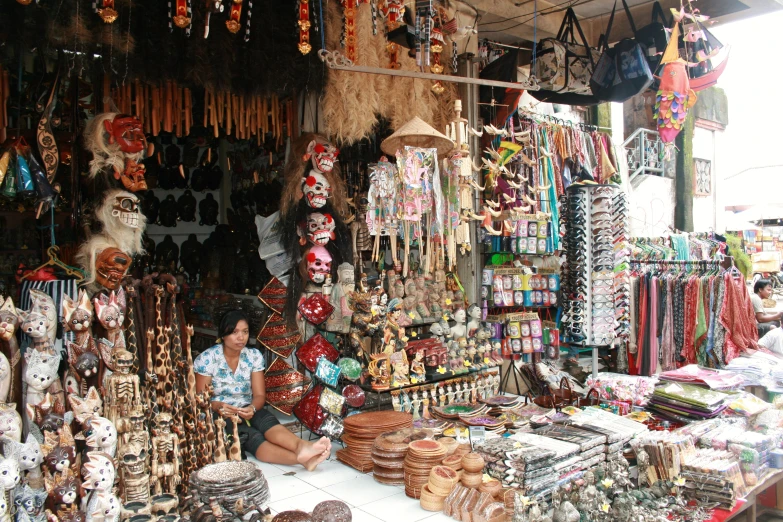 a vendor in front of a market selling lots of celets