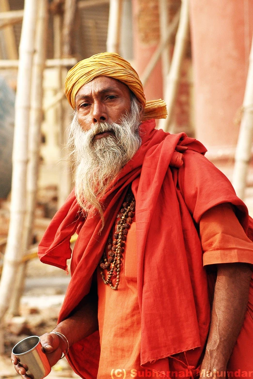 an old man with a beard and orange dress