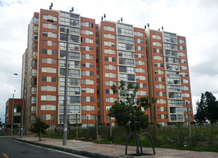 a very tall brown building sitting by the side of the road