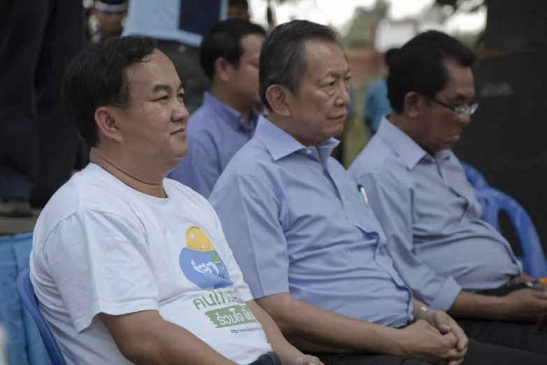 group of people sitting on chairs wearing shirts