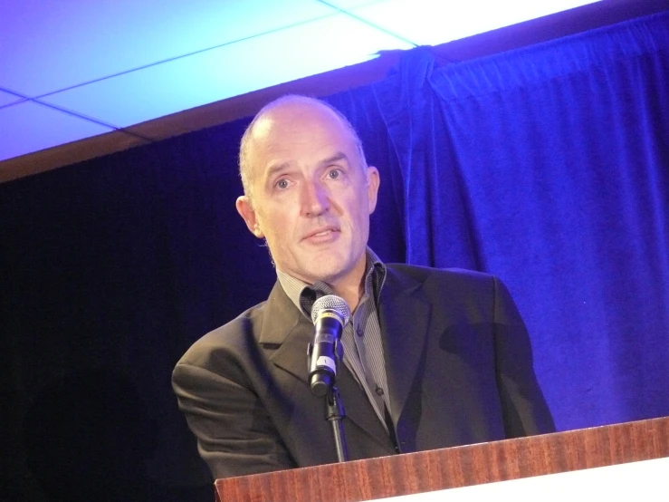 a man in a black suit is at a podium