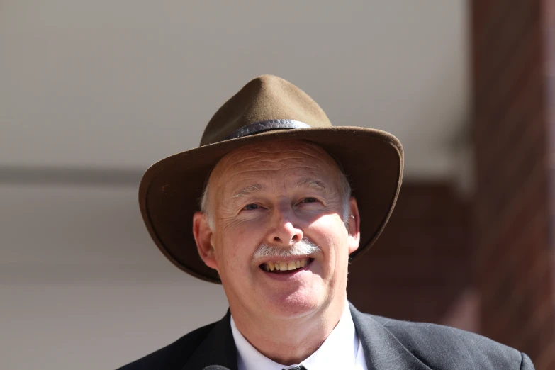 a man with a mustache and hat and tie