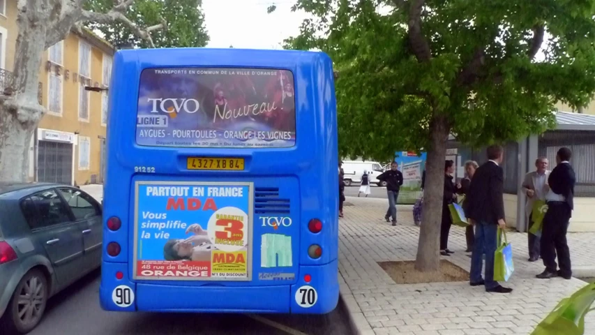 there is a blue bus parked on the side of the road