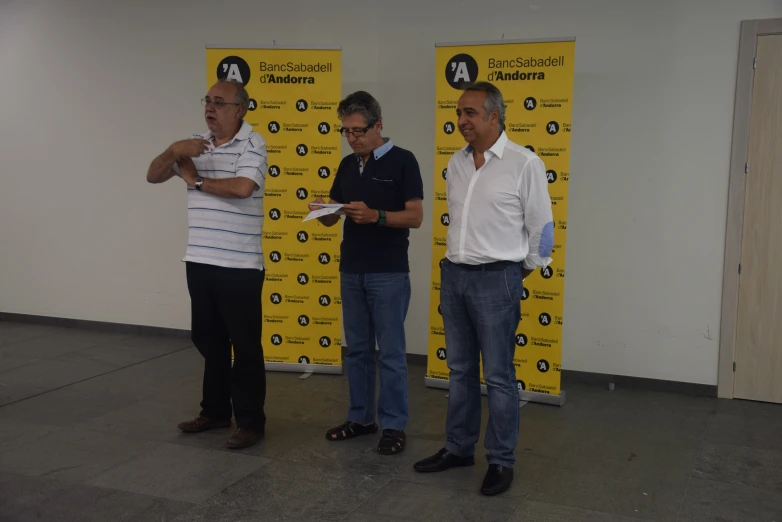 three men are standing in front of a sign