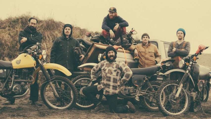 several men on motorcycles sitting on top of each other