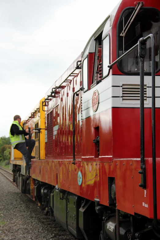 a red train traveling down train tracks next to an ocean