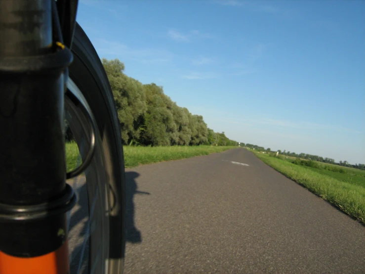 the bike is going down the paved road