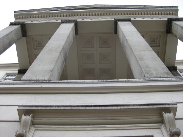 the top of a building with columns and a clock on it