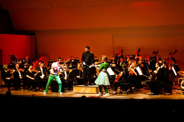 an orchestra with music and people dressed in various colored outfits
