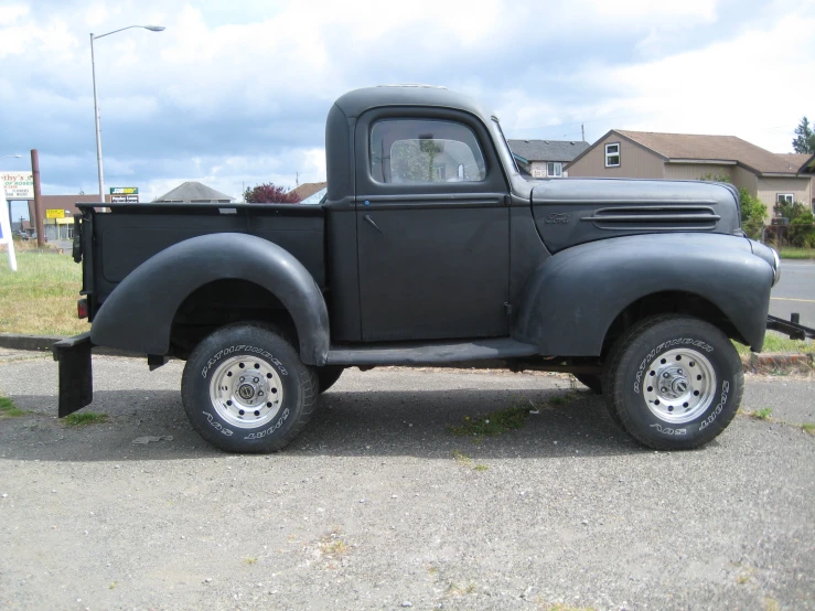 old black truck parked outside with a sky background