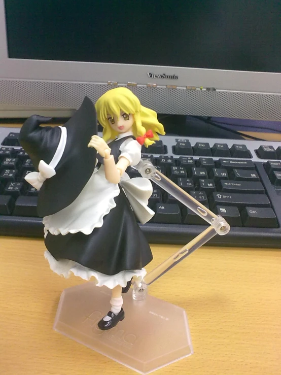 a doll holding a sword stands on a desk