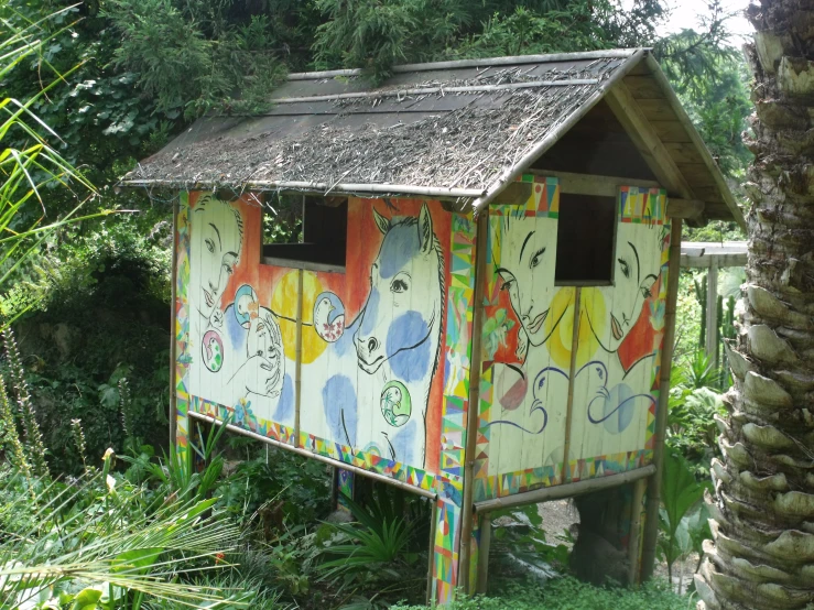 a small painted outhouse in a tropical area