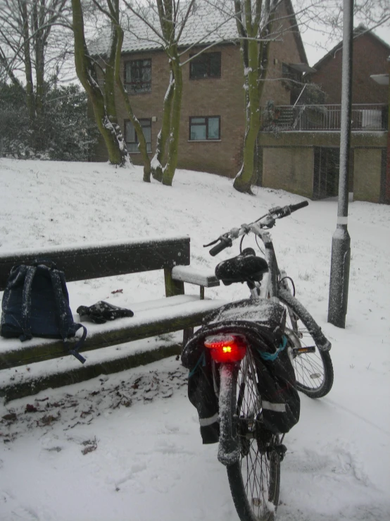 a motorcycle parked next to a wooden bench in the snow