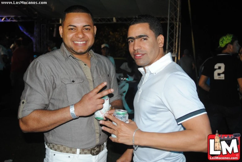 two men are posing for a po and holding drinks