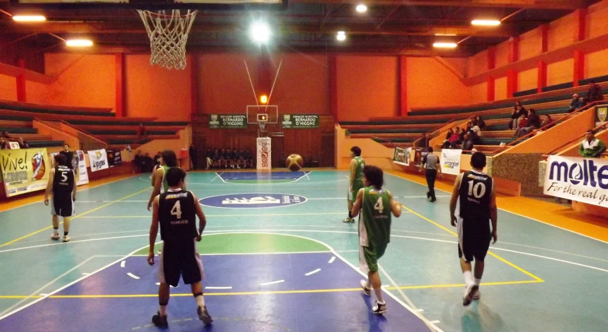 a group of men playing basketball in a building