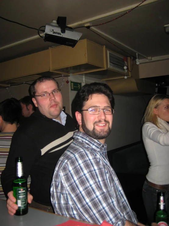 two men are holding beers in their hands