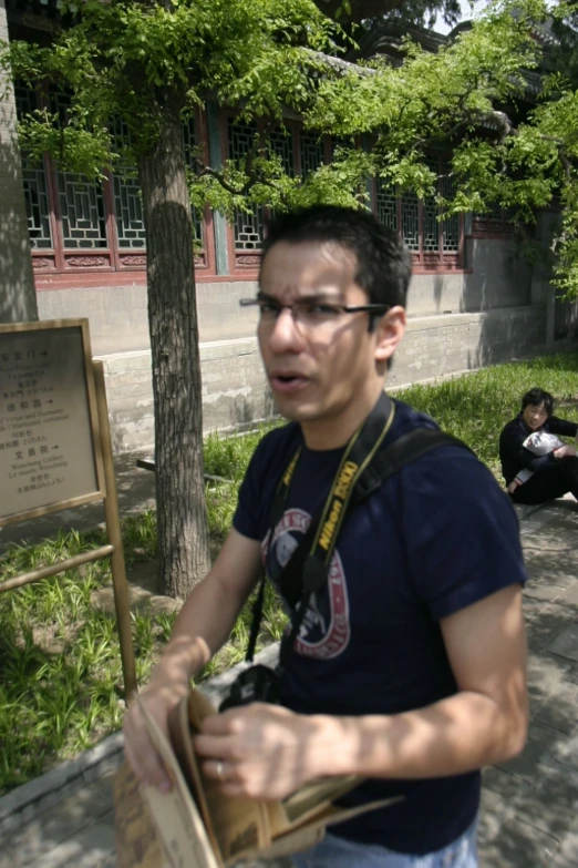 a guy with glasses and blue shirt is skateboarding down a ramp