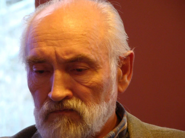 an older man with a white beard and beard in the middle of his eyes