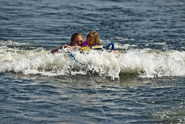 two s playing in the ocean on their surfboard