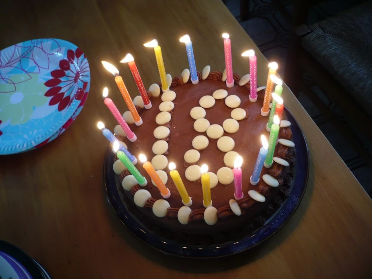 a birthday cake with lit candles that are all arranged around it