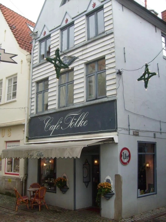 a small white building sitting in front of a tall white building