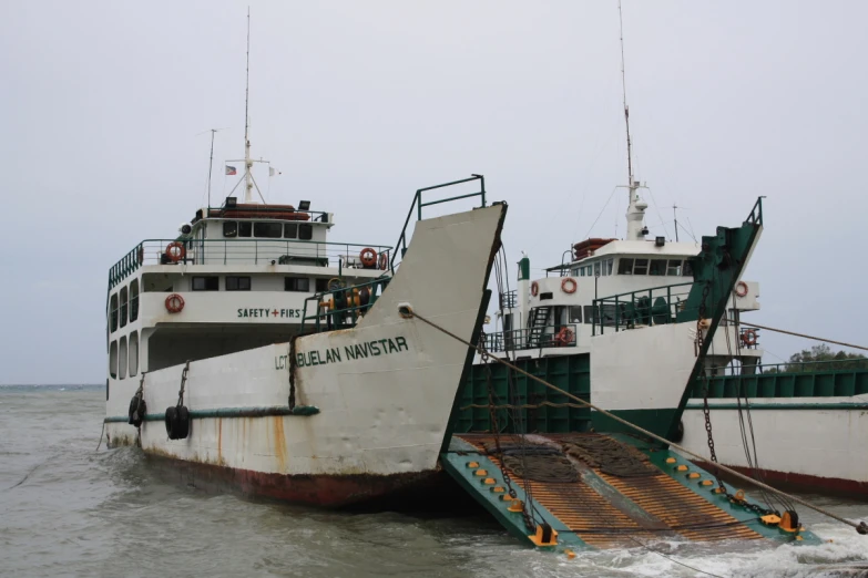 a boat sitting next to another ship in the water