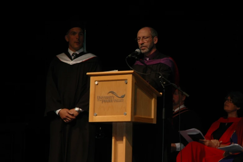 a person in a priest outfit is talking into a microphone