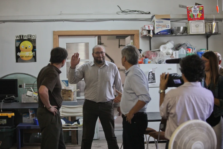 a group of men talking while standing around