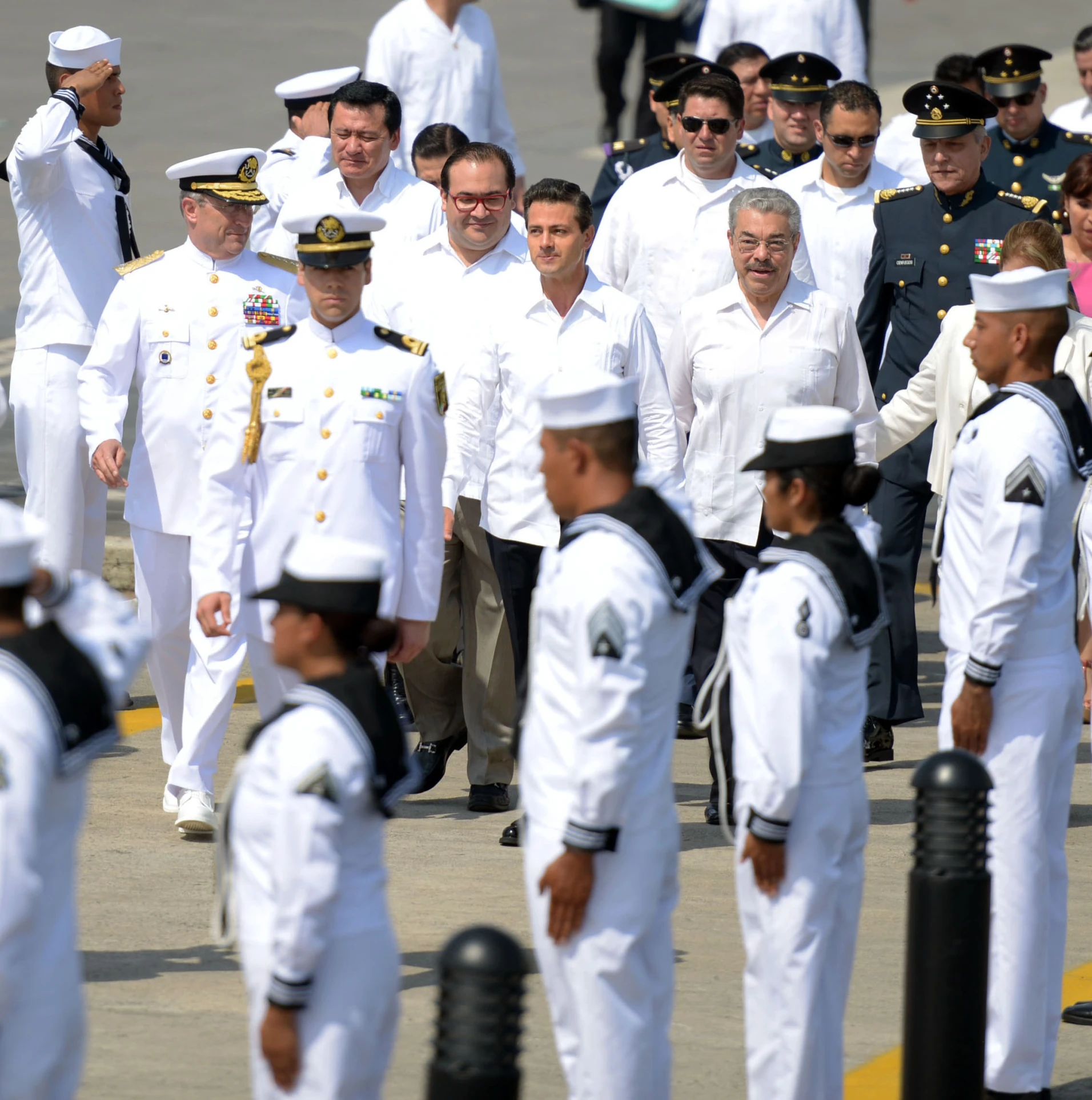 a group of sailors walking with other members