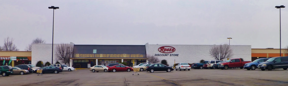 some cars are in a lot in front of a store