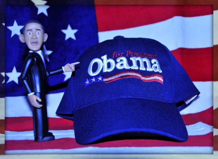 a hat with an obama and a black plastic figure