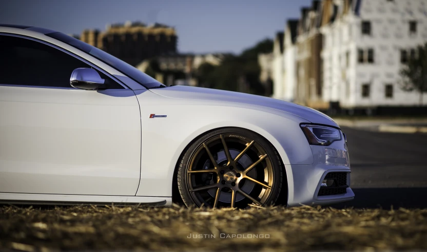 the front of a car with golden wheels on the road