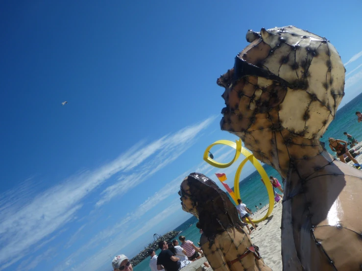 people standing on the beach next to large plastic objects