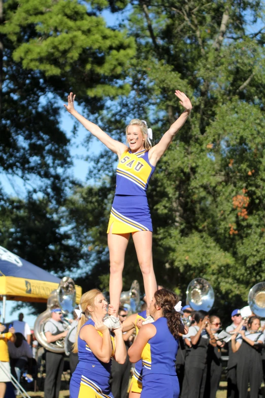 two cheerleaders in yellow and blue jump into the air