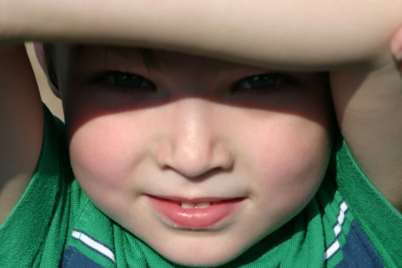 a child looking up to its head in the sun