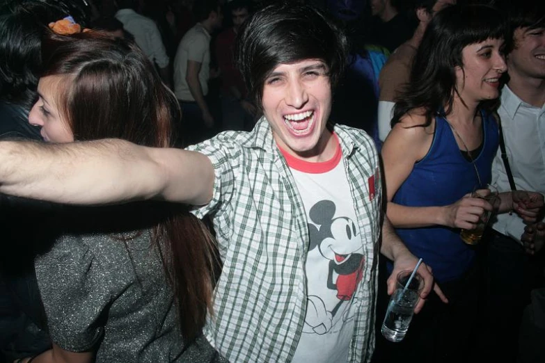 a person in a crowd is dancing with his arms spread out
