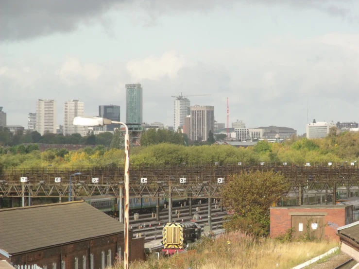 a large train traveling past a city in the background