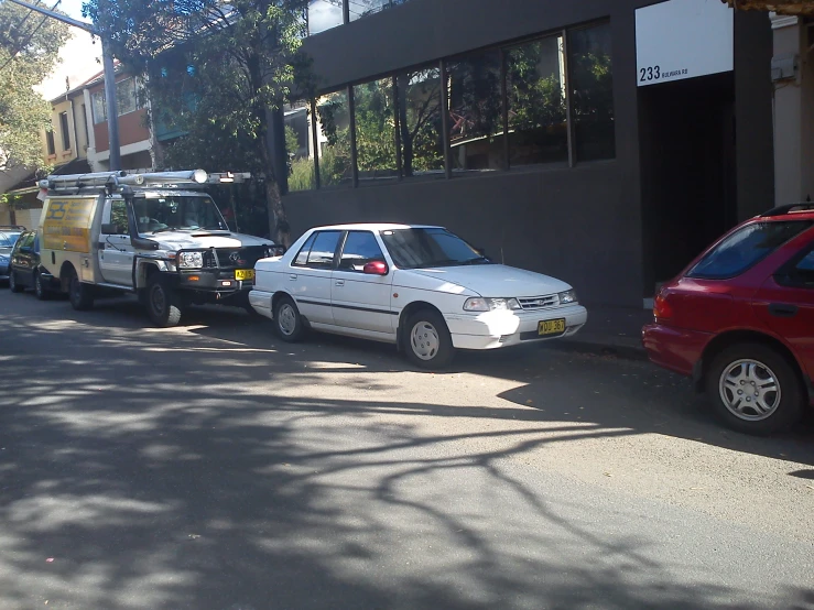 two cars on the side of a building next to each other