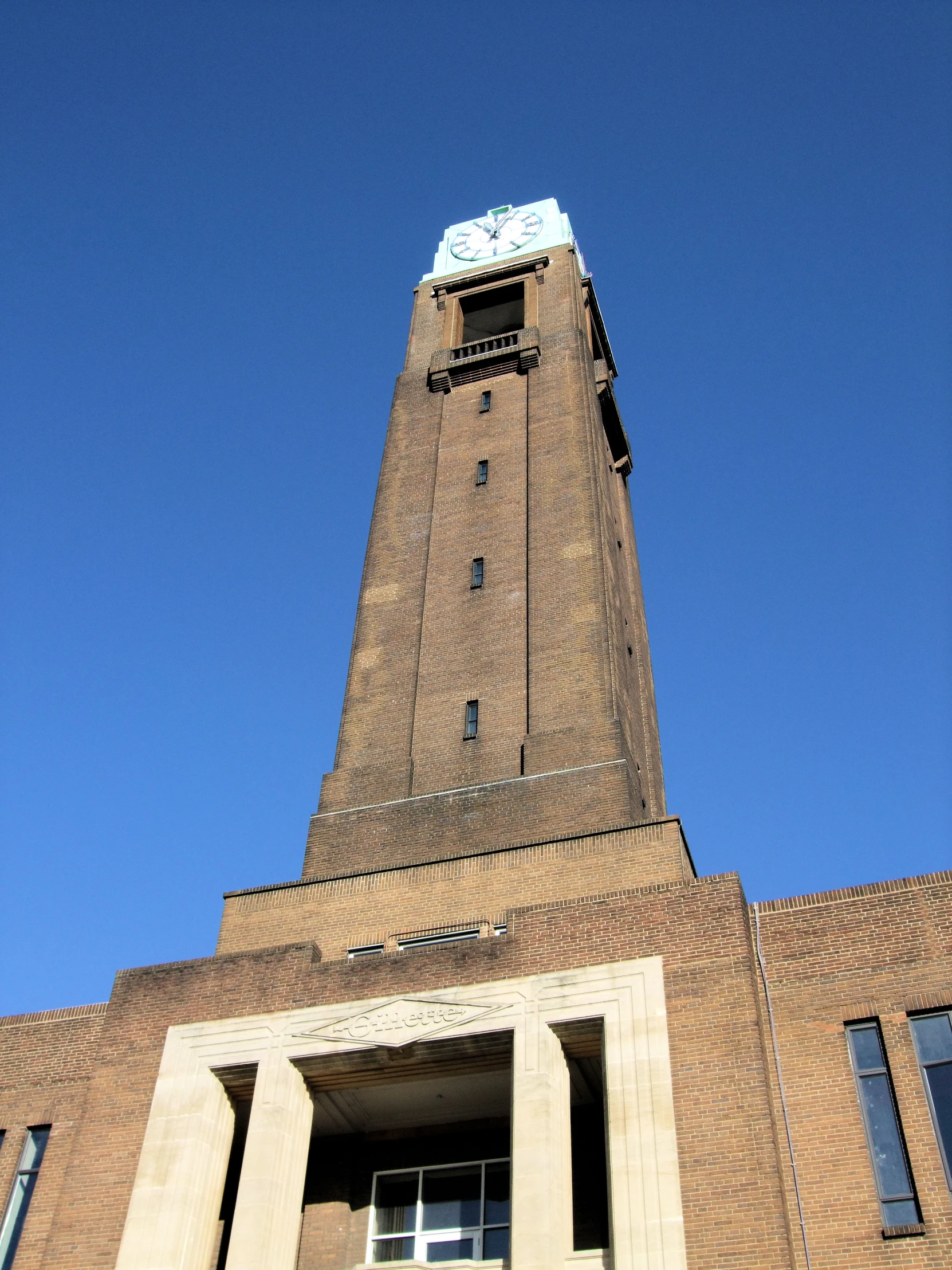 an upward view of a clock tower that is built into the side of a building