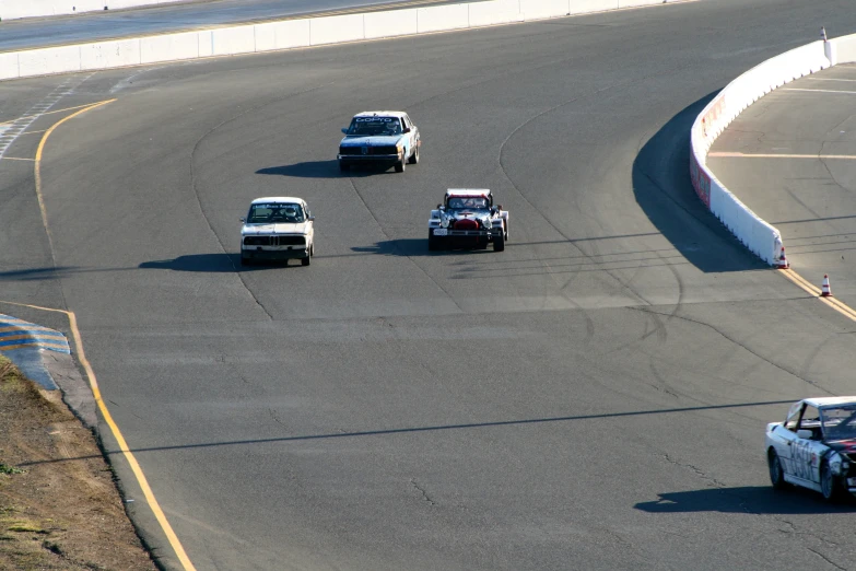 a group of vehicles driving on a curved track