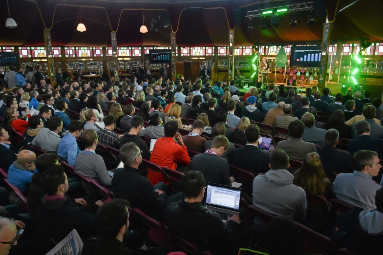 the crowd is gathered around laptop computers during a show