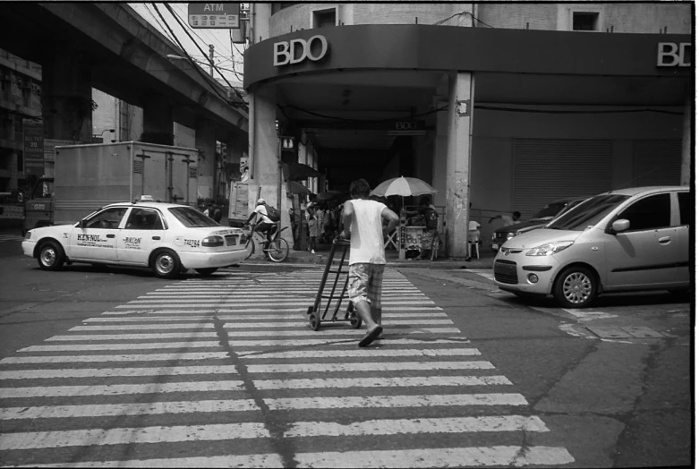 a person with a suitcase and some cars in a city