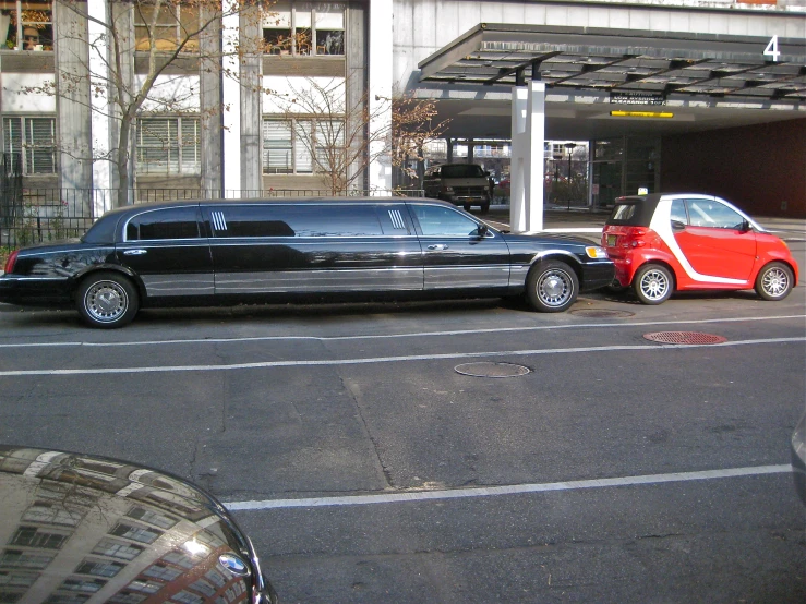 cars are parked on a street in front of a large building